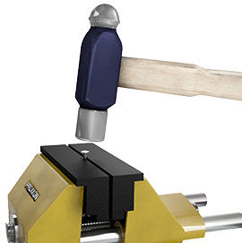 A hammer positioned above a wire secured in a vice.